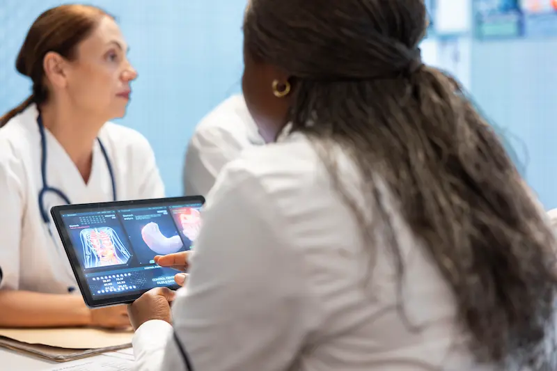 Healthcare providers reviewing patient health information during a medical evaluation